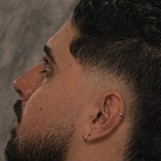Detalhe de degradê bem marcado na lateral, com barba feita