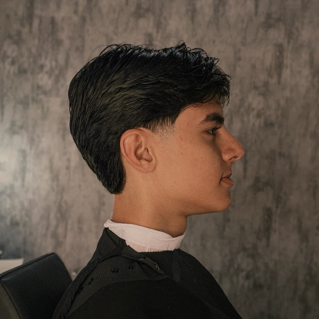 Corte taper fade com topo mais longo penteado para trás